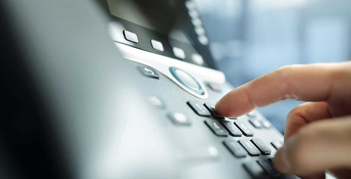 Close Up of Hand Dialling Telephone